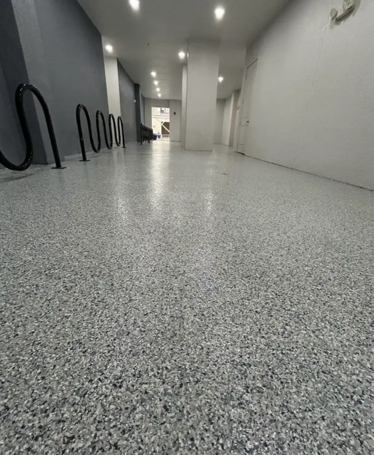 A grey broadcast flake floor running down a building corridor