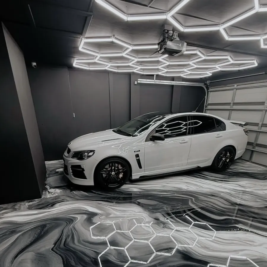 Black and white marbled epoxy garage floor under hexagon lighting